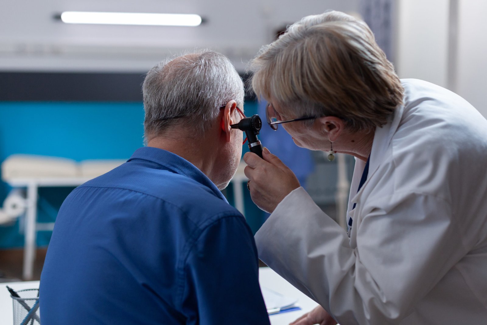 man getting ear wax removal service by a nurse
